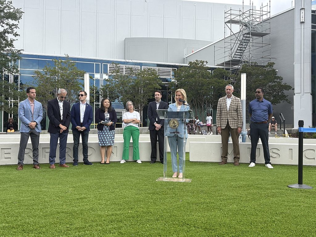Mayor Donna Deegan speaks at the May 13 park opening of Riverfront Music Garden park in Downtown Jacksonville. Behind her are City Council members, city employees and Groundwork Jax CEO Kay Ehas